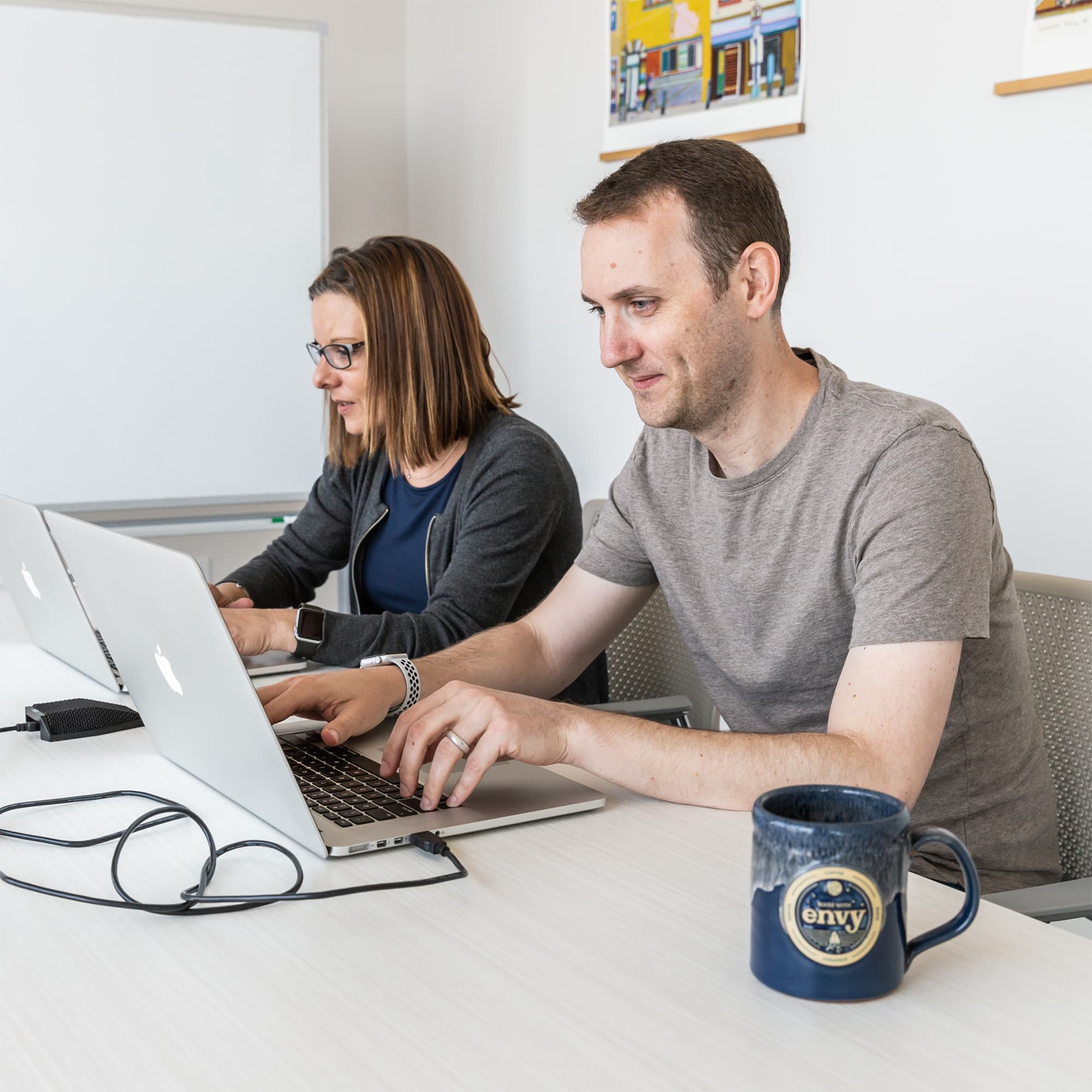 Jennifer Border and Nathaniel Bibler on laptops attending a remote meeting