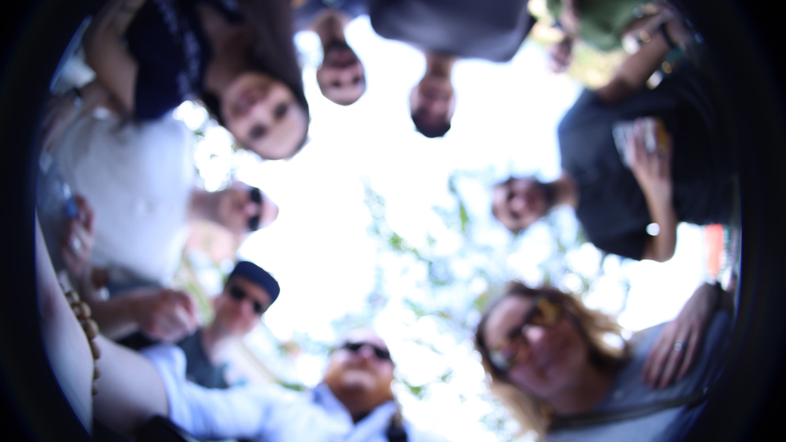 Photographed from below, a blurry image featuring multiple Envy Labs team members circled around the camera