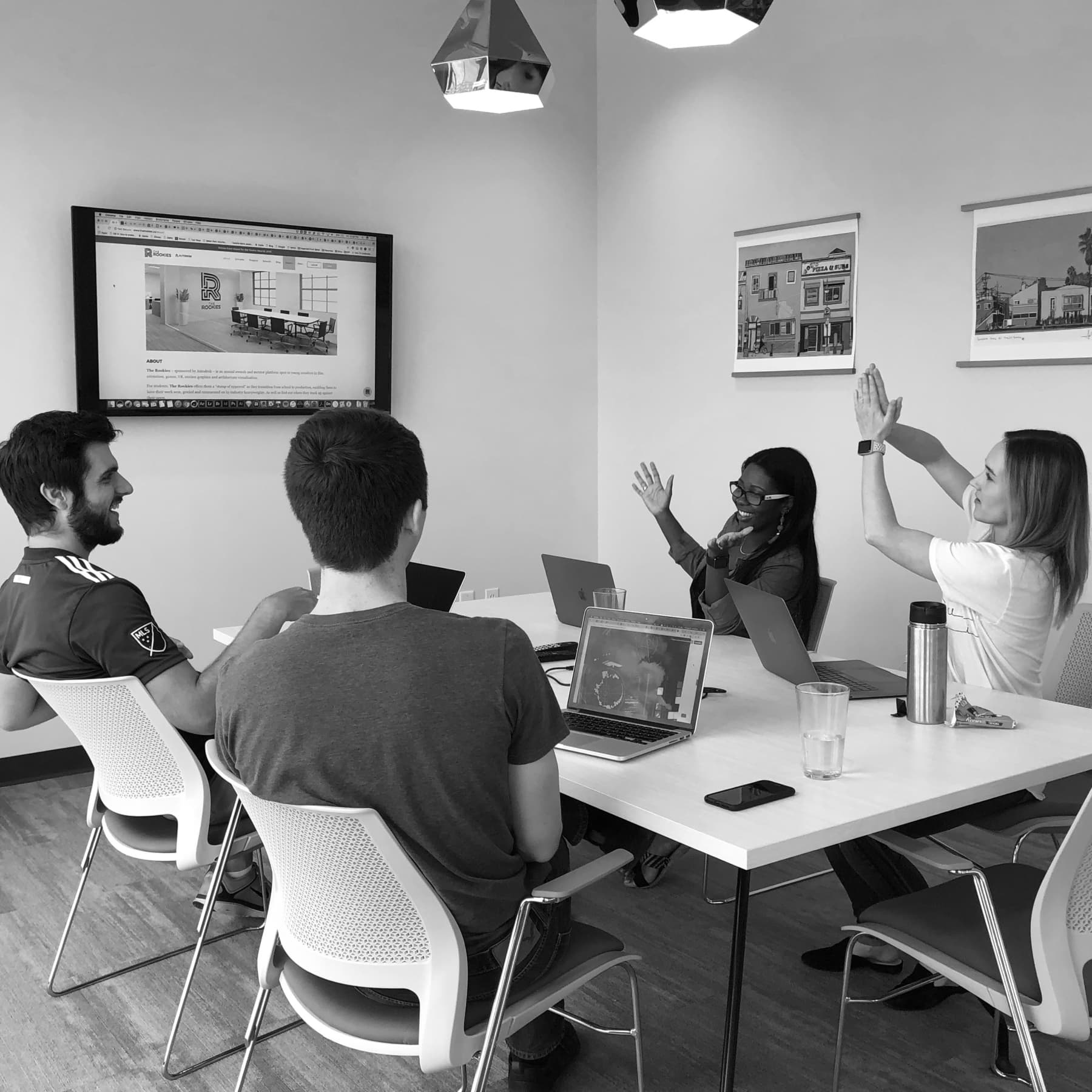 A photo of Envy Labs’ designers demonstrating the app’s hand animations